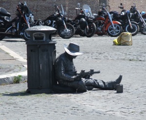 This guy hasn't gotten the memo that 'being a cowboy statue with futuristic guns leaning against a trash can' isn't the most lucrative of professions